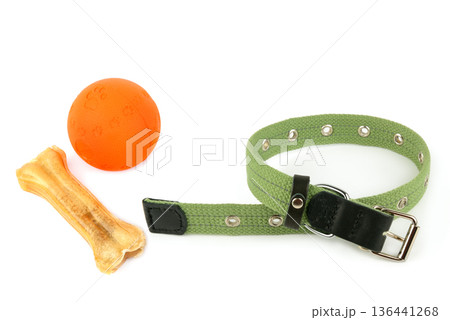 Green textile dog collar with orange ball and rawhide bone on white background Green textile dog collar with orange ball and rawhide bone on white background 136441268