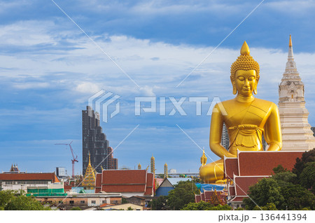 A large seated Buddha or Buddha Dhammakaya Dhepmongkol at Paknam Phasi Charoen temple on a blue sky day. 136441394