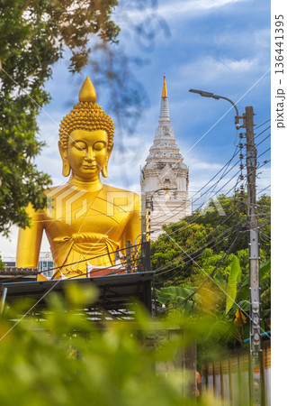 A large seated Buddha or Buddha Dhammakaya Dhepmongkol at Paknam Phasi Charoen temple on a blue sky day. A large seated Buddha or Buddha Dhammakaya Dhepmongkol at Paknam Phasi Charoen temple on a blue sky day. 136441395