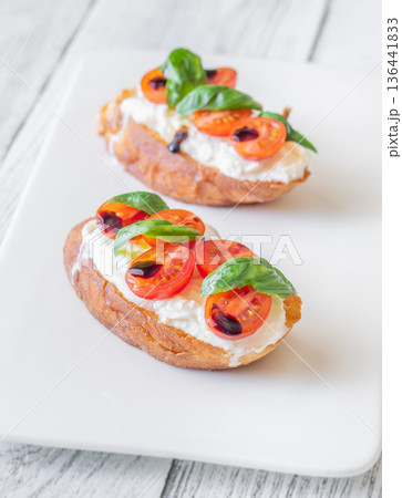 Gourmet bruschetta with stracciatella cherry tomatoes basil and balsamic on bright rustic background Gourmet bruschetta with stracciatella cherry tomatoes basil and balsamic on bright rustic background 136441833