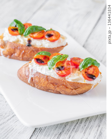 Gourmet bruschetta with stracciatella cherry tomatoes basil and balsamic on bright rustic background Gourmet bruschetta with stracciatella cherry tomatoes basil and balsamic on bright rustic background 136441834