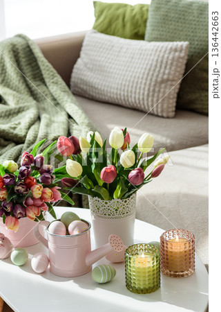 Easter Table with Tulip Bouquets, Eggs, Candles and Festive Decor. Cozy Spring Arrangement 136442663