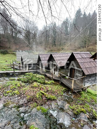 Traditional wooden water mills in Jajce, Bosnia, surrounded by flowing streams and mossy rocks, creating a scenic rural landscape with heritage and nature harmony Traditional wooden water mills in Jajce, Bosnia, surrounded by flowing streams and mossy rocks, creating a scenic rural landscape with heritage and nature harmony 136443190
