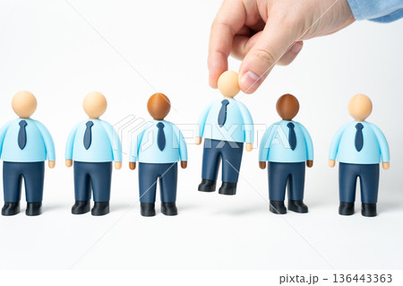 A hand selects one office worker from a selection. Hiring is done through a competitive process. Talent screening highlights merit. Recruitment strategy builds strong teams. A hand selects one office worker from a selection. Hiring is done through a competitive process. Talent screening highlights merit. Recruitment strategy builds strong teams. 136443363