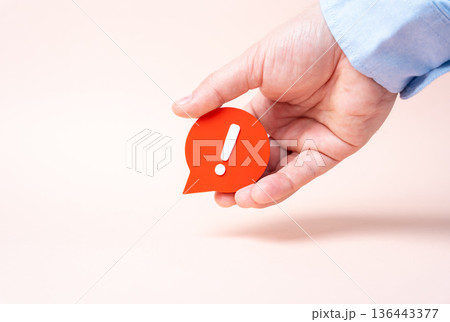 A hand holds a comment with an exclamation mark. A harsh comment, a sharp reaction. A complaint and dissatisfaction. Feedback culture shapes reputation, crisis response, and brand trust. A hand holds a comment with an exclamation mark. A harsh comment, a sharp reaction. A complaint and dissatisfaction. Feedback culture shapes reputation, crisis response, and brand trust. 136443377