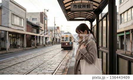 電停で路面電車を待っている女性 136443409