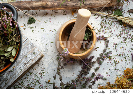 pestle and mortar around dry medicine herbs at white background. top view 136444620
