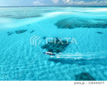 Aerial view of floating boat in clear azure sea in summer 136444877