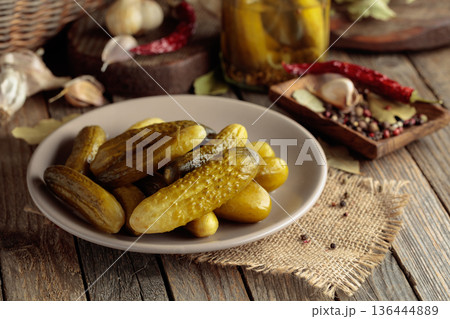 Homemade canned gherkins on a rustic wooden background. 136444889