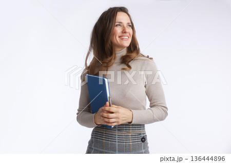 Confident Businesswoman Looking Aside with Blue Notebook Confident Businesswoman Looking Aside with Blue Notebook 136444896