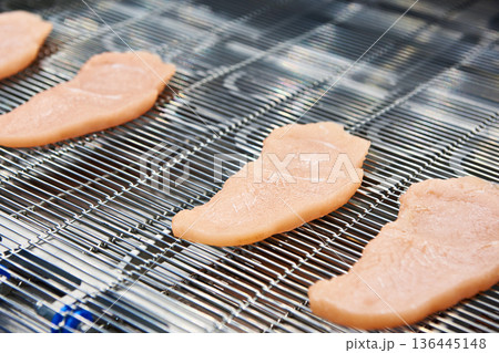 Pieces of meat on conveyor belt machine 136445148
