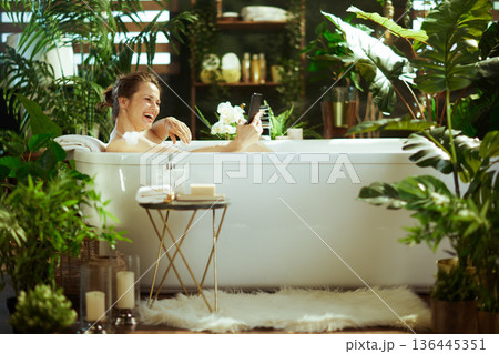 Joyful Woman Laughing in a Relaxing Bubble Bath Joyful Woman Laughing in a Relaxing Bubble Bath 136445351