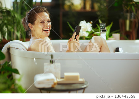 Joyful Woman Laughing in Bubble Bath Joyful Woman Laughing in Bubble Bath 136445359