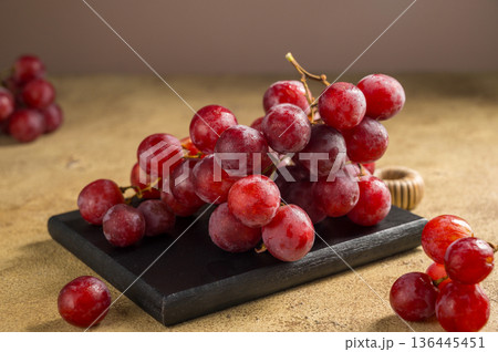 Pink grapes on brown neutral background, autumn harvest concept. Pink grapes on brown neutral background, autumn harvest concept. 136445451