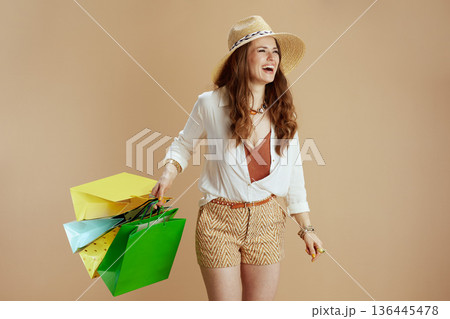 happy elegant woman in blouse and shorts isolated on beige 136445478