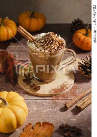 Pumpkin spice latte, coffee drink in glass cup with pumpkins, autumn hot drink Pumpkin spice latte, coffee drink in glass cup with pumpkins, autumn hot drink 136445482
