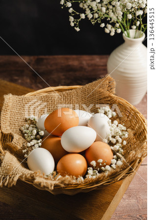 Easter eggs background. White eggs in rustic bowl and gypsophila flowers. Spring holiday 136445515