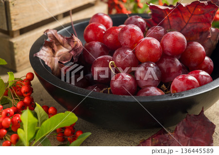 Pink grapes in black wooden bowl, autumn harvest concept. Pink grapes in black wooden bowl, autumn harvest concept. 136445589