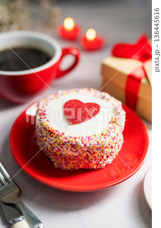 Valentine's Day festive red background. Cake with red heart, cup of coffee, gift box and gypsophila flower 136445616