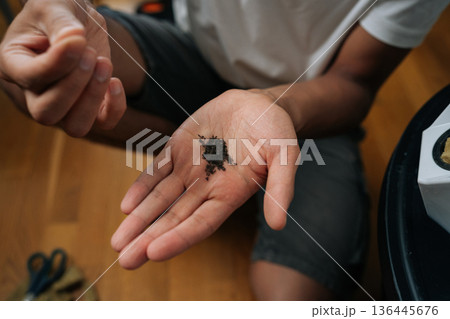 Urban farmer holding small seeds in open palm, preparing to plant them in rockwool cubes for hydroponic tower garden, promoting sustainable and innovative indoor gardening. Concept of home farming. Urban farmer holding small seeds in open palm, preparing to plant them in rockwool cubes for hydroponic tower garden, promoting sustainable and innovative indoor gardening. Concept of home farming. 136445676