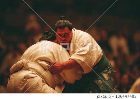 Sumo wrestler lifts opponent with a powerful throw during a traditional match in Japan 136447485