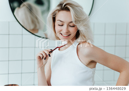 Close up view on toothbrush with toothpaste in smiling blonde woman hand 136448029