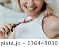 Close up view on toothbrush with toothpaste in smiling blonde woman hand 136448030