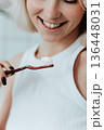 Close up view on toothbrush with toothpaste in smiling blonde woman hand 136448031
