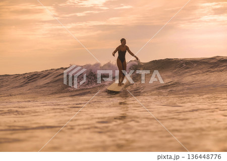 Instructor Demonstrating Longboard Techniques In Peaceful Sunset Environment 136448776