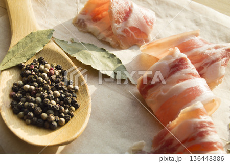 Delicious bacon rolls and a wooden spoon with spices Delicious bacon rolls and a wooden spoon with spices 136448886