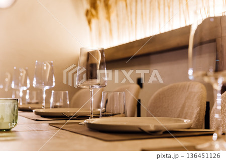 Elegant restaurant table with wine glasses, candles and pampas grass backdrop Elegant restaurant table with wine glasses, candles and pampas grass backdrop 136451126