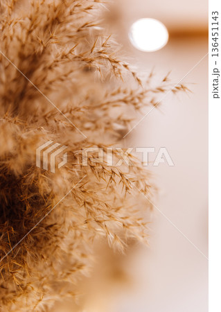 Boho fireplace mantel with macrame wall hanging, candles and dried flowers 136451143