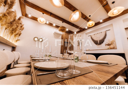 Elegant restaurant table with wine glasses, candles and pampas grass backdrop Elegant restaurant table with wine glasses, candles and pampas grass backdrop 136451144