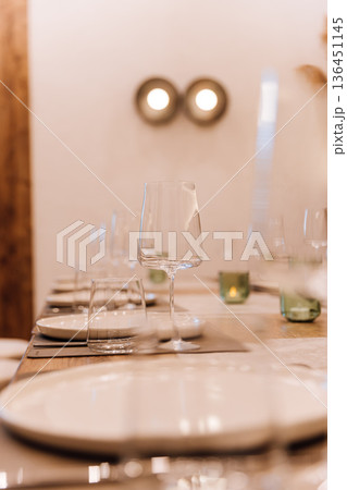 Elegant wine glass on set restaurant table with warm candlelight bokeh 136451145