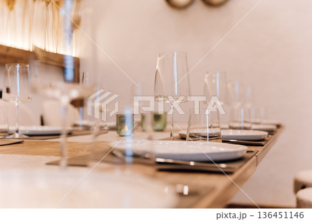 Wine glass on set restaurant table with warm candlelight and pampas decor Wine glass on set restaurant table with warm candlelight and pampas decor 136451146