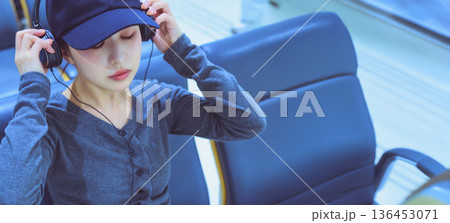 女性がイヤホン装着 ■撮影協力:関西国際空港(KIX) 女性がイヤホン装着 ■撮影協力:関西国際空港(KIX) 136453071