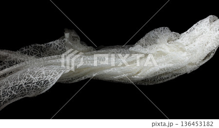 White lace fabric flying in curve shape, Piece of textile white lace fabric throw fall in air. Black background isolated, dark shading environment 136453182