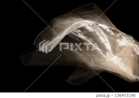 Yellow gold organza fabric flying in curve shape, Piece of textile Yellow gold organza fabric throw fall in air. Black background isolated, dark shading environment 136453190