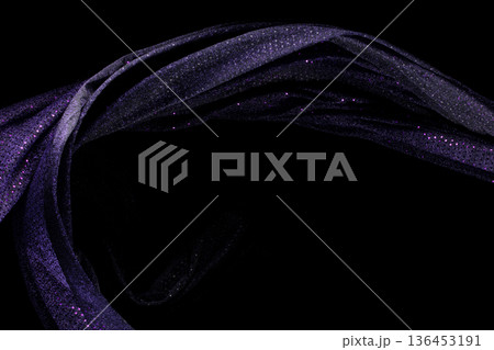 Purple violet glitter fabric flying in curve shape, Piece of textile Purple violet glitter fabric throw fall in air. Black background isolated, dark shading environment 136453191