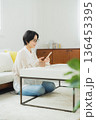 リビングでスマホを見る女性 136453395