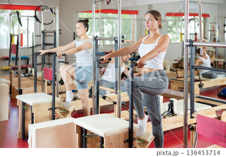 Young woman engaged in leg workouts on combo chair 136453714