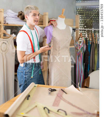 Young male tailor working with mannequin Young male tailor working with mannequin 136453769