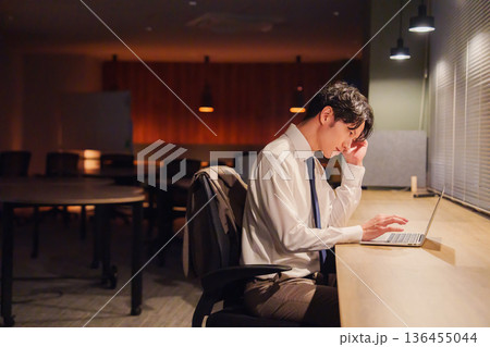 夜遅くまで残業をする若い男性スタッフ 136455044