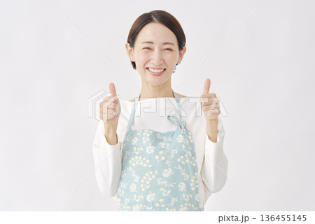 エプロンをつけた女性　グッドサイン　白背景 136455145