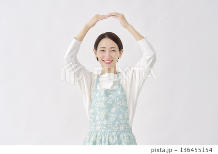 エプロンをつけた女性　丸印のジェスチャー　白背景 136455154