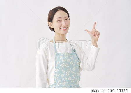エプロンをつけた女性　チェックサインのジェスチャー　白背景 136455155