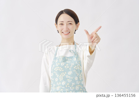 エプロンをつけた女性 チェックサインのジェスチャー 白背景 エプロンをつけた女性 チェックサインのジェスチャー 白背景 136455156