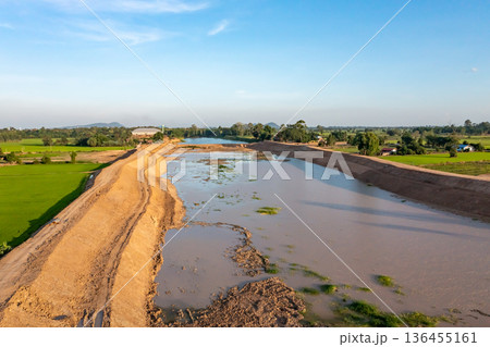 Construction dredges up for a canal and dam, to prevent a flood in the rainy season. Date on 14 May 2021 at Uthai Thani province, Thailand. Construction dredges up for a canal and dam, to prevent a flood in the rainy season. Date on 14 May 2021 at Uthai Thani province, Thailand. 136455161