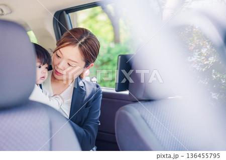子供と一緒にタクシーに乗る忙しいお母さん 子供と一緒にタクシーに乗る忙しいお母さん 136455795