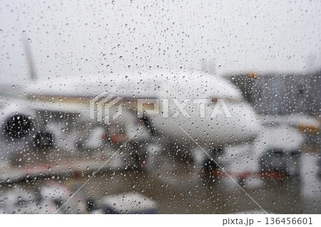 雨粒がついた窓ガラス越しの飛行機 雨粒がついた窓ガラス越しの飛行機 136456601